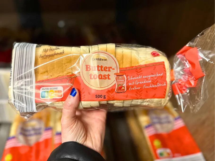 Eine Hand hält den Goldähren Buttertoast von Aldi