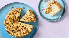 Käsekuchen mit cremiger Füllung und knusprigen Streuseln, angerichtet auf einem blauen Teller, ein Stück separat serviert. - Foto: LECKER @ Bauer Media Group Käsekuchen mit cremiger Füllung und knusprigen Streuseln, angerichtet auf einem blauen Teller, ein Stück separat serviert. - Foto: LECKER @ Bauer Media Group