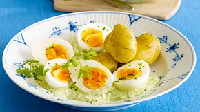 Ein Teller mit Kartoffeln mit Schale, grüner Soße und 5 halbierten Eiern auf blauem Hintergrund.. - Foto: LECKER @ Bauer Media Group Ein Teller mit Kartoffeln mit Schale, grüner Soße und 5 halbierten Eiern auf blauem Hintergrund.. - Foto: LECKER @ Bauer Media Group