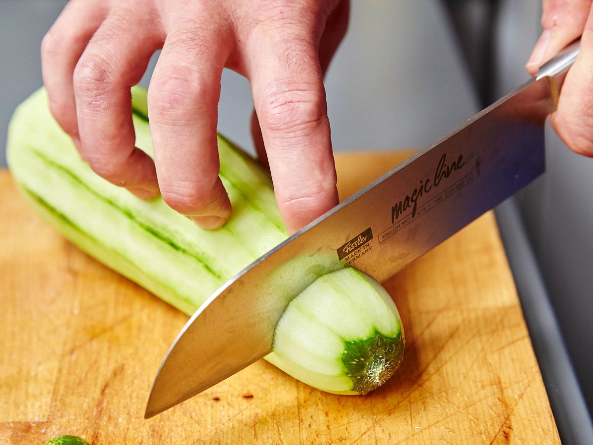 Schmorgurkenenden großzügig abschneiden Schmorgurkenenden werden mit einem großen Messergroßzügig abgeschnitten.