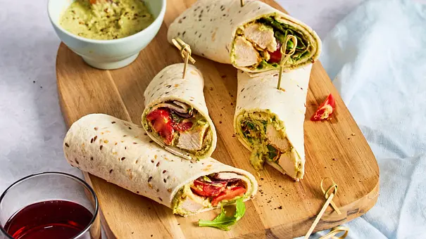4 Hähnchen-Wraps mit Bärlauch-Hummus auf einem Holzbrett - Foto: LECKER @ Bauer Media Group
