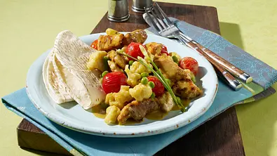 Hähnchencurry mit Blumenkohl, Erbsen und Kirschtomaten Rezept - Foto: LECKER @ Bauer Media Group