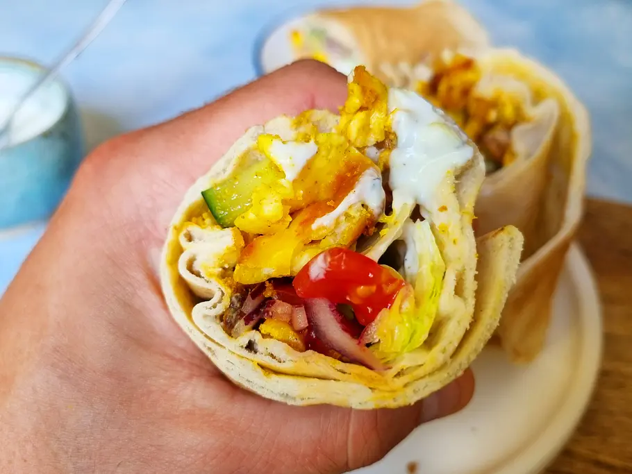 Halloumi-Shawarma in Hand Halloumi-Shawarma in der Hand man erkennt den Käse, Dip und Salat.