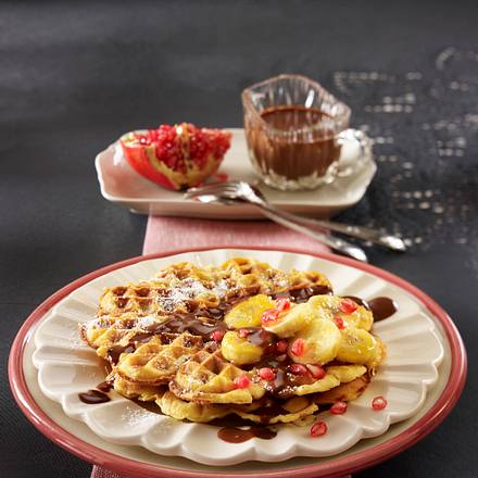Haselnuss-Waffeln mit Schokosoße, Honigbananen und Granatapfelkernen Rezept