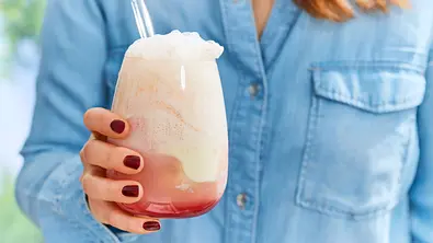 Erdbeer Float mit schaumiger Limonadenkrone und einer Kugel Vanilleeis in einem runden Glas, mit Strohhalm serviert. - Foto: LECKER @ Bauer Media Group