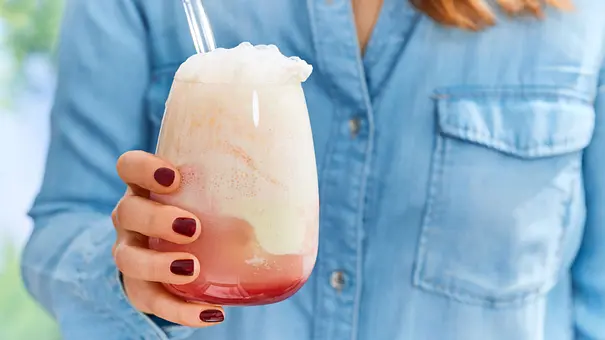 Erdbeer Float mit schaumiger Limonadenkrone und einer Kugel Vanilleeis in einem runden Glas, mit Strohhalm serviert. - Foto: LECKER @ Bauer Media Group