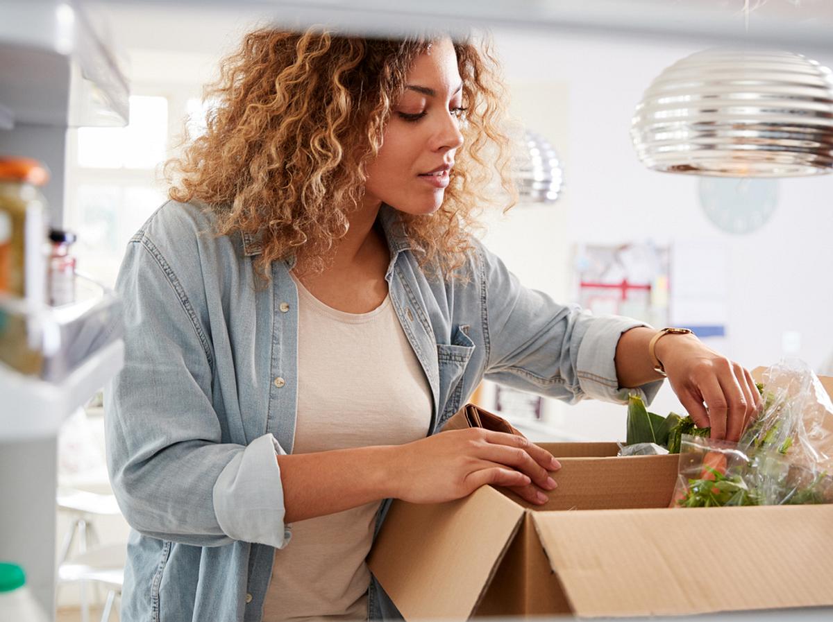 Frau packt Kochbox aus