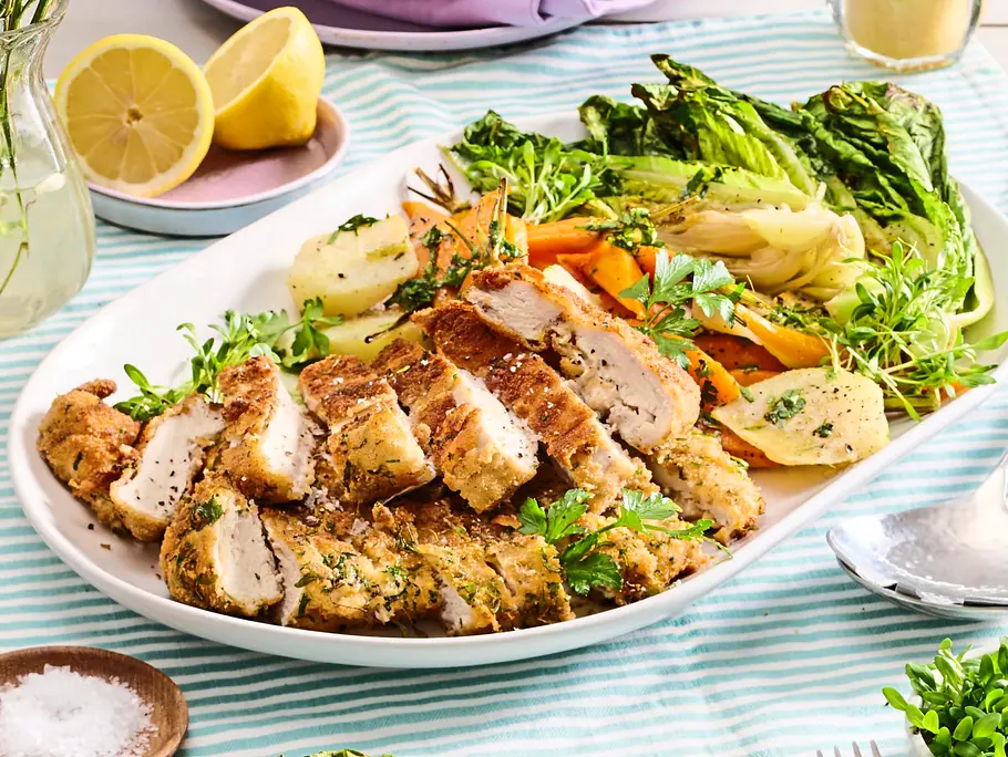 Schnitzelstreifen mit Kräuterpanade serviert mit Salat auf einem Teller
