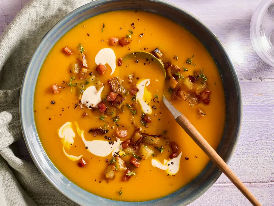 Kürbis-Apfelsuppe mit Kartoffel-Croûtons in einer Schüssel angerichtet