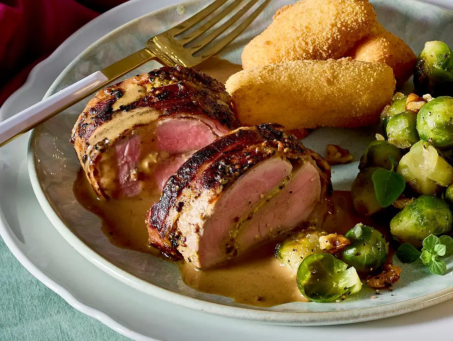 Feine Whiskey-Filets auf einem Teller mit Kroketten und Rosenkohl angerichtet Feine Whiskey-Filets auf einem Teller mit Kroketten und Rosenkohl angerichtet