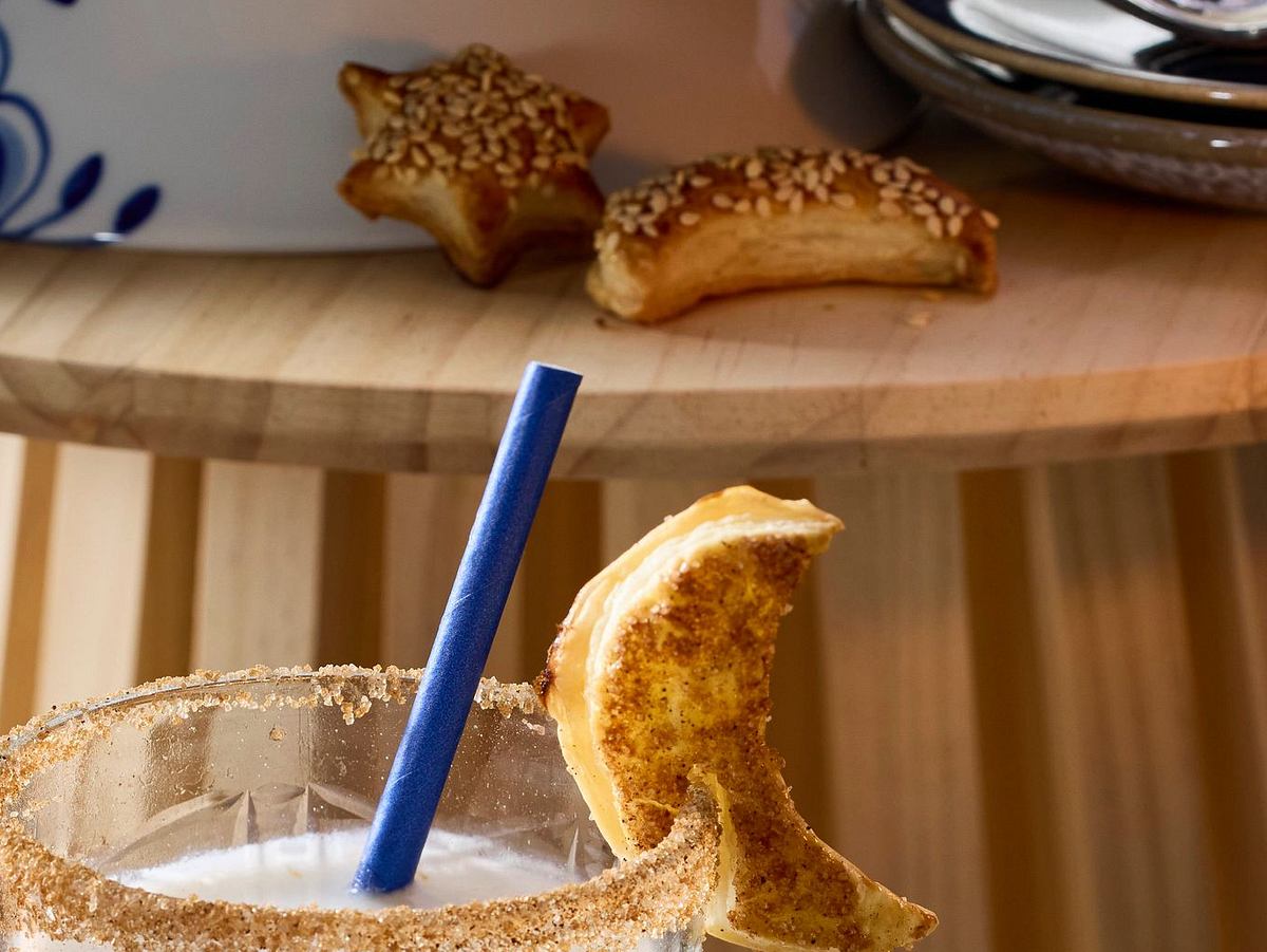 Knusprige Himmelsboten in Mond- und Sternform als Gebäck an den Cocktailgläsern und auf dem Tisch neben der Tortenplatte.