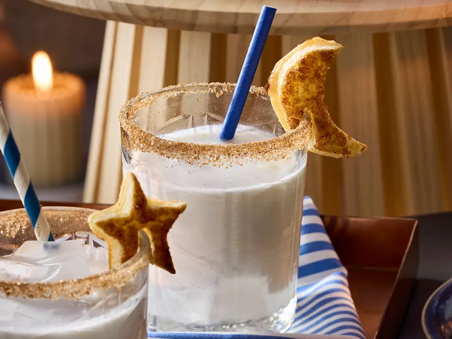Geheimnisvolle-Rita: Weißer Cocktail mit Zimt-Zucker-Rand und Blätterteigmonde.