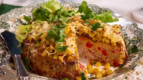 Herzhafte, runde Hackfleisch-Torte mit einer goldbraunen Kartoffelwürfelkruste, garniert mit gehackter Petersilie und gefüllt mit roten Paprikastückchen. Ein Stück ist bereits herausgeschnitten. - Foto: LECKER @ Bauer Media Group