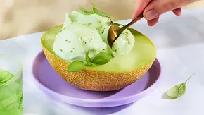 Drei Kugeln hellgrünes Melonen-Limetten-Sorbet in einer ausgehöhlten Melonenhälfte, angerichtet auf einem fliederfarbenen Teller. Daneben ein Glas grünes Getränk mit Limettenscheibe und Basilikum. - Foto: StockFood Studios / Meike Bergmann Drei Kugeln hellgrünes Melonen-Limetten-Sorbet in einer ausgehöhlten Melonenhälfte, angerichtet auf einem fliederfarbenen Teller. Daneben ein Glas grünes Getränk mit Limettenscheibe und Basilikum. - Foto: StockFood Studios / Meike Bergmann