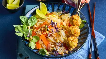 Low Carb-Pad Thai aus Gemüsenudeln, bunten Streifen, Kräutern und gehackten Erdnüssen, serviert mit Geflügelhackbällchen am Spieß auf einem blau gemusterten Teller und platzierter heller Serviette. - Foto: LECKER @ Bauer Media Group Low Carb-Pad Thai aus Gemüsenudeln, bunten Streifen, Kräutern und gehackten Erdnüssen, serviert mit Geflügelhackbällchen am Spieß auf einem blau gemusterten Teller und platzierter heller Serviette. - Foto: LECKER @ Bauer Media Group
