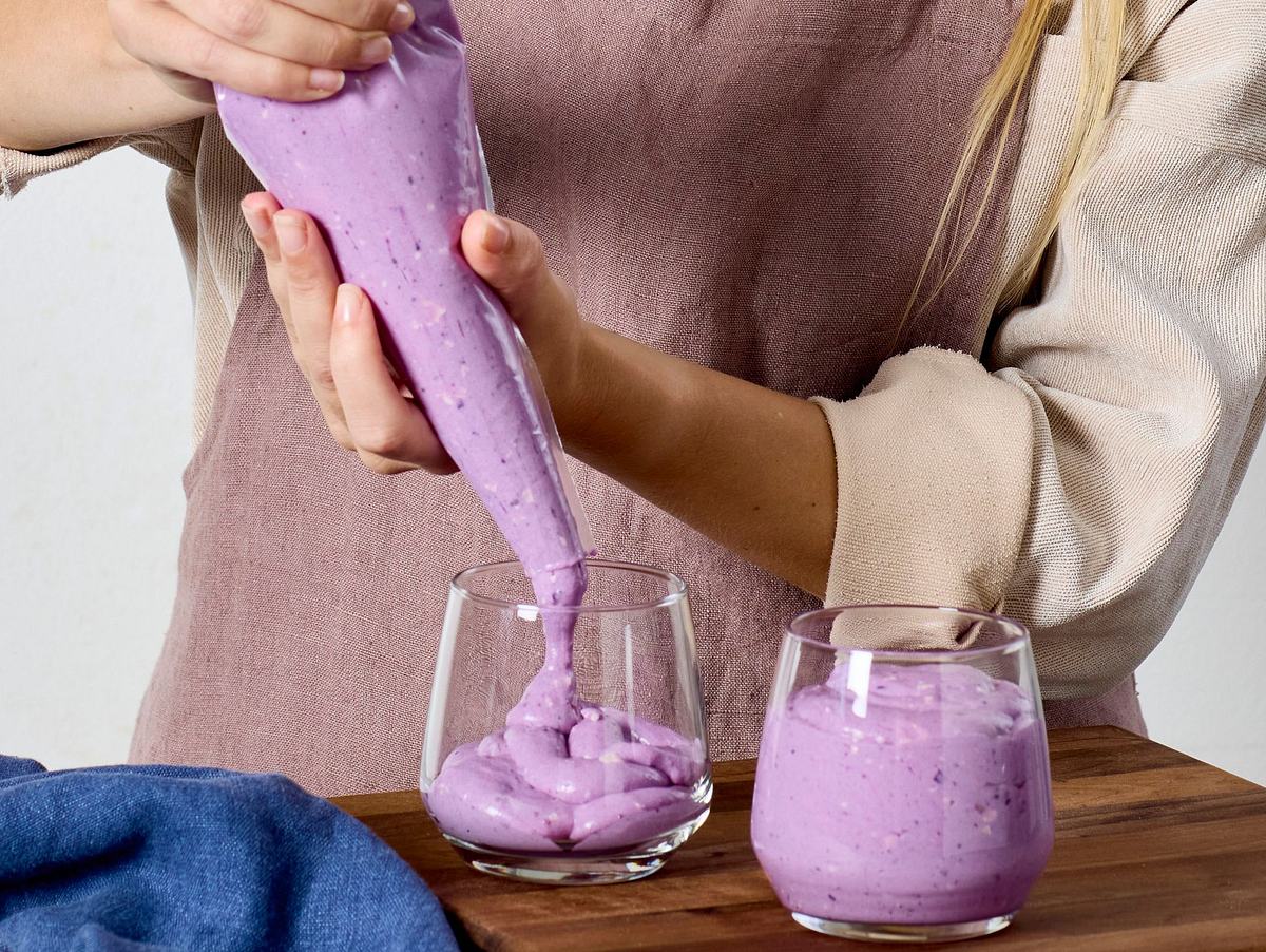 Ladycreme mit Ube Rezept Mit einem Spritzbeutel wird die Creme in Gläser gefüllt
