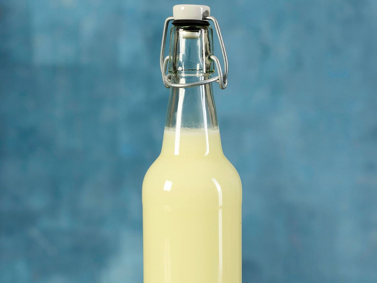 Hellgelbe Molke in einer verschließbaren Glasflasche.