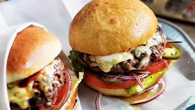 Zwei selbst gemachte Cheeseburger mit Beef-Patty, Tomate, Salat und geschmolzenem Käse - Foto: LECKER @ Bauer Media Group
