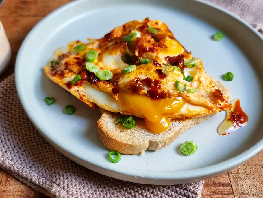 Hot Honey Eggs Rezept Spiegeleier mit Chili-Öl, Honig und Frühlingszwiebeln auf Toastbrot.
