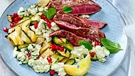 Ein blauer Teller mit gebratenen Zucchini-Streifen, Feta, Granatapfel und Hüftsteak-Streifen. - Foto: LECKER @ Bauer Media Group