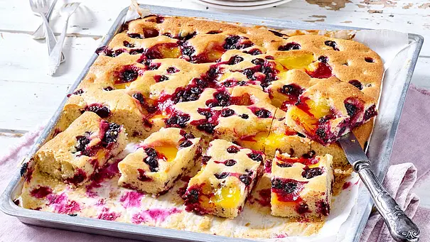Rührkuchen vom Blech mit schwarzen Johannisbeeren, ein Teil davon in Stücke geschnitten - Foto: LECKER @ Bauer Media Group Rührkuchen vom Blech mit schwarzen Johannisbeeren, ein Teil davon in Stücke geschnitten - Foto: LECKER @ Bauer Media Group