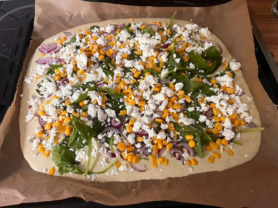 Herzhafter Pfannkuchen vom Blech Üppig bestreuter Blechpfannkuchen mit Spinat, Mais, Feta und roter Zwiebel.
