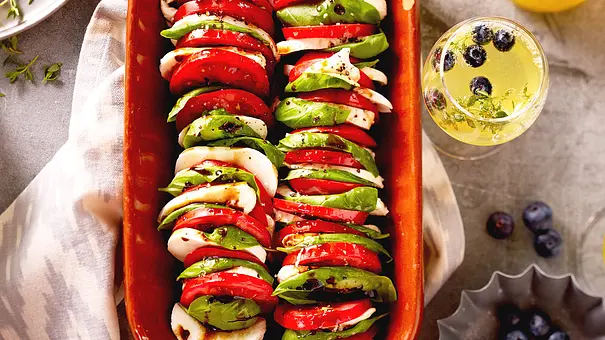 Insalata Caprese hochkant geschichtet in einer braunen Steingut-Auflaufform - Foto: LECKER @ Bauer Media Group Insalata Caprese hochkant geschichtet in einer braunen Steingut-Auflaufform - Foto: LECKER @ Bauer Media Group