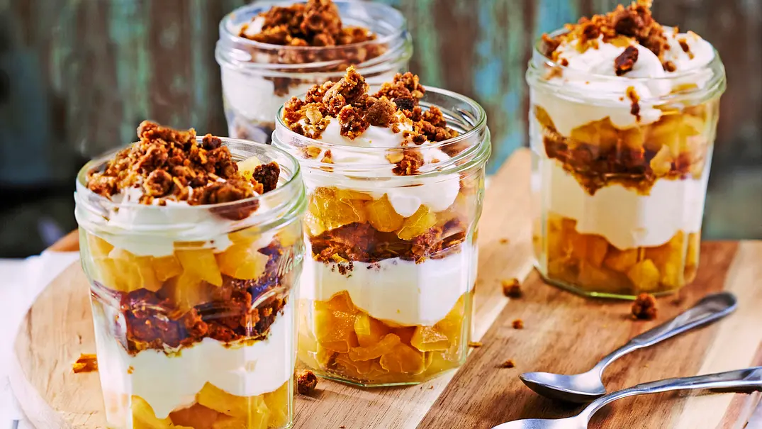 4 Schraubgläser gefüllt mit geschichtetem Joghurt-Apfel-Trifle und goldbraunen Streuseln - Foto: LECKER @ Bauer Media Group 4 Schraubgläser gefüllt mit geschichtetem Joghurt-Apfel-Trifle und goldbraunen Streuseln - Foto: LECKER @ Bauer Media Group