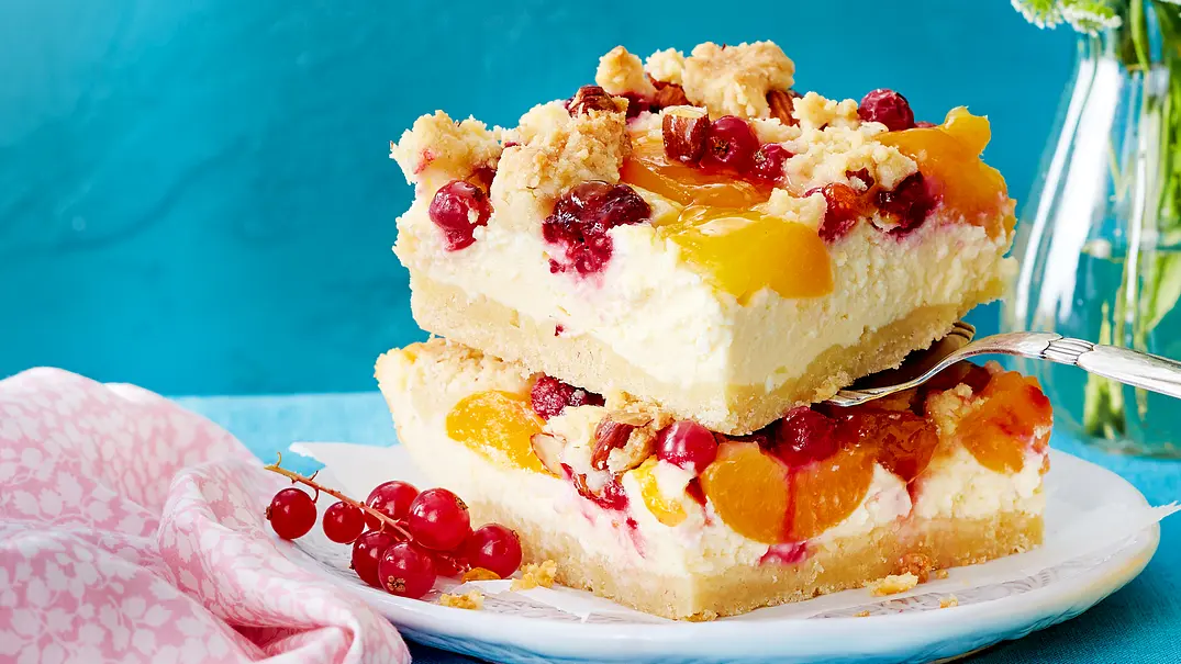 Zwei viereckige Johannisbeer-Aprikosen-Kuchen-Stücke auf einem kleinen Teller serviert. Ein Stück wird auf einer Gabel gerade serviert. Der Teller ist mit einem kleinen Strauch Johannisbeeren verziert. Rezept - Foto: LECKER @ Bauer Media Group Zwei viereckige Johannisbeer-Aprikosen-Kuchen-Stücke auf einem kleinen Teller serviert. Ein Stück wird auf einer Gabel gerade serviert. Der Teller ist mit einem kleinen Strauch Johannisbeeren verziert. Rezept - Foto: LECKER @ Bauer Media Group