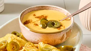Ein Platte mit Nachos und einem Schälchen Käse-Dip für Nachos, garniert mit Jalapeno-Scheiben - Foto: LECKER @ Bauer Media Group