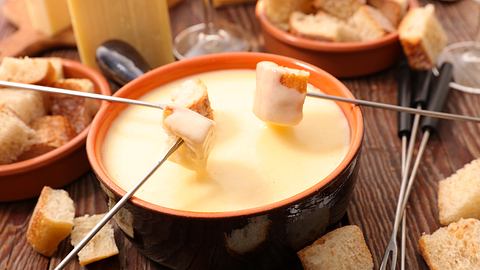 Käsefondue-Set aus Gusseisen mit passenden Fonduegabeln - Foto: iStock/margouillatphotos