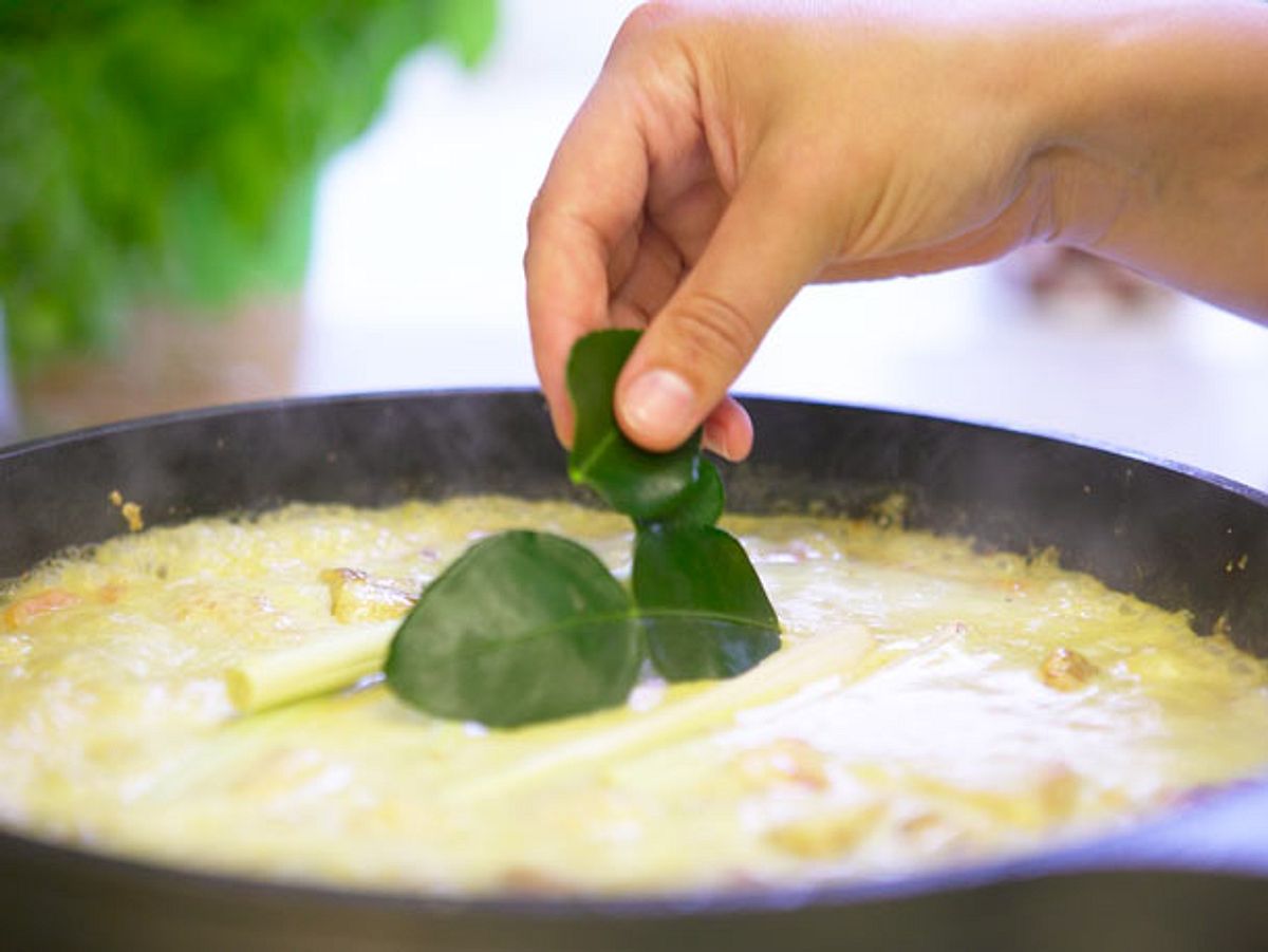 Kaffirlimettenblätter ins Hähnchen-Curry geben