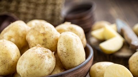 Viele Kartoffeln in brauner Holzschüssel - Foto: iStock/YelenaYemchuk