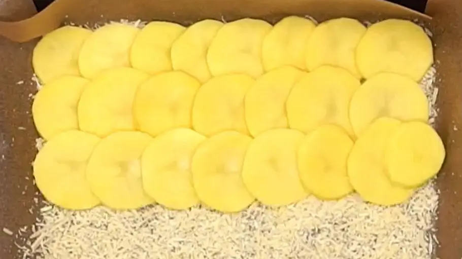 Die Kartoffelscheiben werden fächerartig auf dem Parmesan verteilt