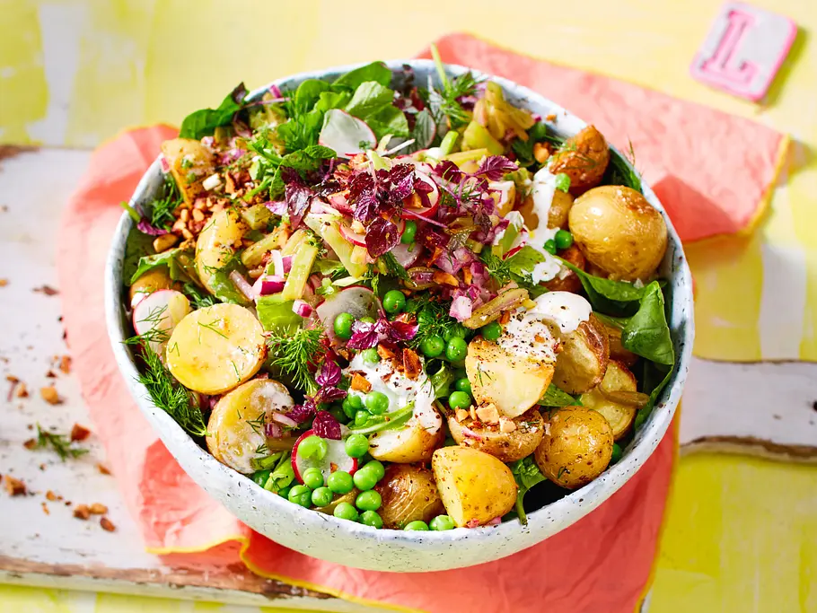 Eine Schale voll mit Kartoffelsalat, buntem Gemüse und Mandelcrunch
