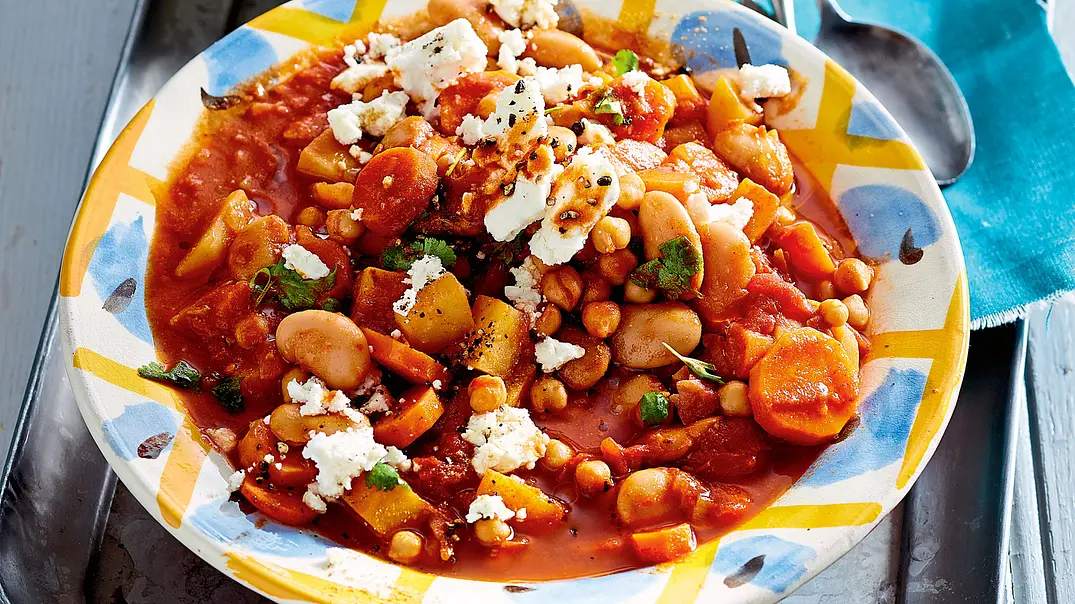 Kichererbsen-Stew mit Möhren und Feta auf einem gelb-blau gemusterten Teller - Foto: LECKER @ Bauer Media Group Kichererbsen-Stew mit Möhren und Feta auf einem gelb-blau gemusterten Teller - Foto: LECKER @ Bauer Media Group