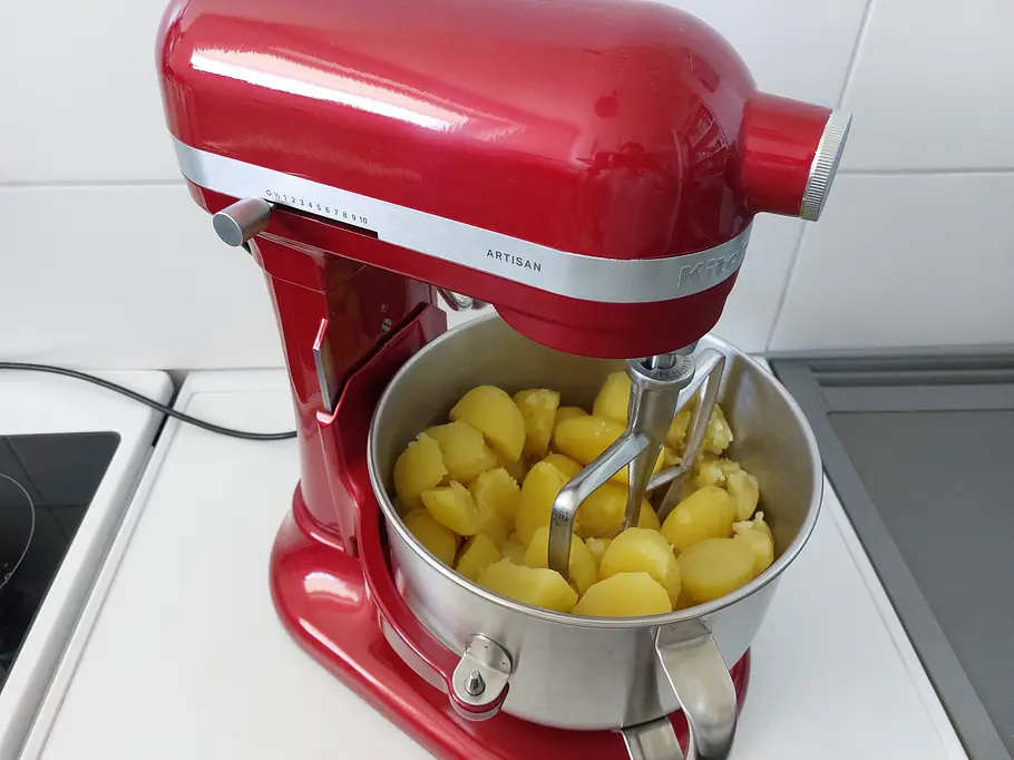 KitchenAid Artisan 6,6 l Kartoffeln pürieren Gekochte Kartoffeln liegen in einer Metallschüssel einer roten KitchenAid Küchenmaschine, bereit zum Pürieren.