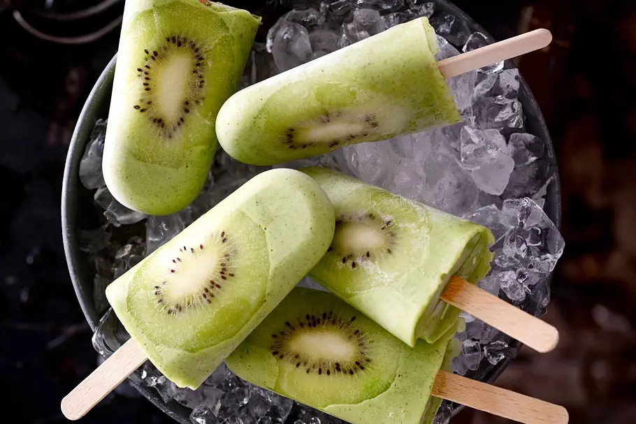 Kiwi-Eis am Stiel in einem Eiskübel.