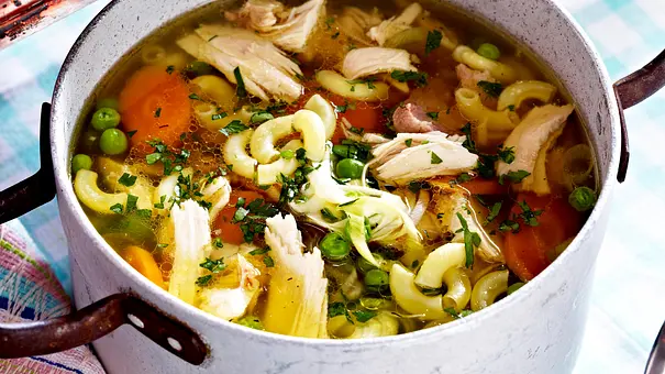 Klassische Hühnersuppe mit Nudeln und Gemüse in einem alten silbernen Kochtopf - Foto: LECKER @ Bauer Media Group