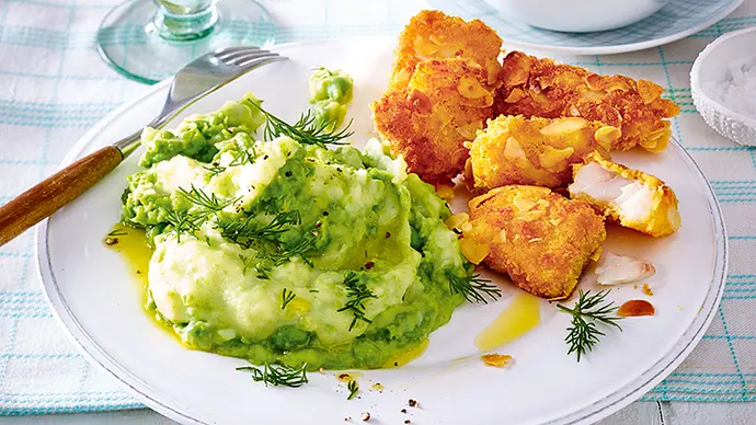 Goldbraun gebratene Fisch-Nuggets mit Kartoffel-Erbsen-Püree auf einem weißen Teller - Foto: LECKER @ Bauer Media Group Goldbraun gebratene Fisch-Nuggets mit Kartoffel-Erbsen-Püree auf einem weißen Teller - Foto: LECKER @ Bauer Media Group