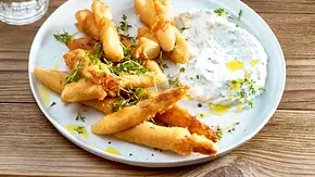 Knuspriger Spargel im Teigmantel mit Kräuter-Dip auf einem weißen Teller - Foto: LECKER @ Bauer Media Group