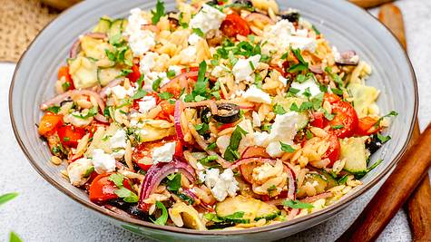 Kritharaki-Salat mit Feta in einer großen Schüssel mit frischer Petersilie - Foto:  ShowHeroes