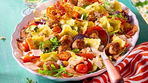 Kunterbunte Sommer-Ravioli mit Cherrytomaten, roten Zwiebeln und Rucola auf einem Servierteller - Foto: House of Food / Bauer Food Experts KG