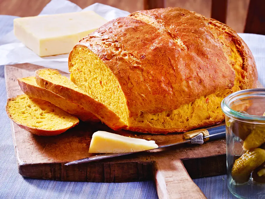 Kürbisbrot-Rezept Kürbisbrot liegt aufgeschnitten auf einem Holzbrett.