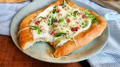 Ungarische Langos: Teigfladen mit weißer Creme, Käse, Lauchzwiebel und Speck belegt. - Foto: LECKER @ Bauer Media Group / Max Bergmann Ungarische Langos: Teigfladen mit weißer Creme, Käse, Lauchzwiebel und Speck belegt. - Foto: LECKER @ Bauer Media Group / Max Bergmann
