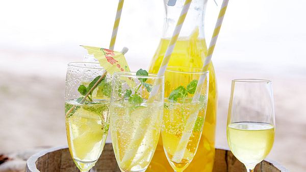 3 Sektgläser mit Limoncello Spritz, im Hintergrund eine befüllte Glaskaraffe - Foto: House of Food / Bauer Food Experts KG