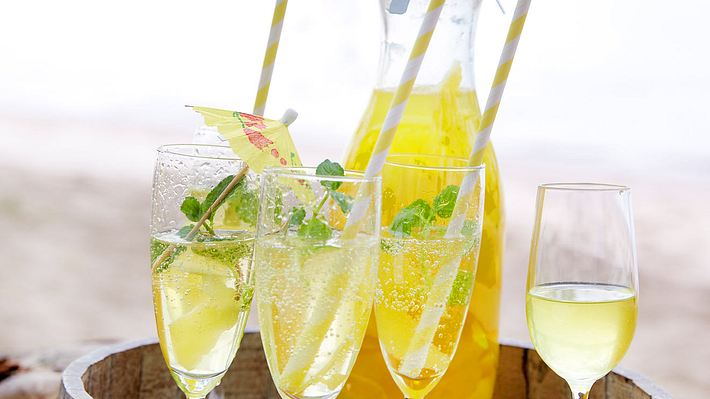 3 Sektgläser mit Limoncello Spritz, im Hintergrund eine befüllte Glaskaraffe - Foto: House of Food / Bauer Food Experts KG