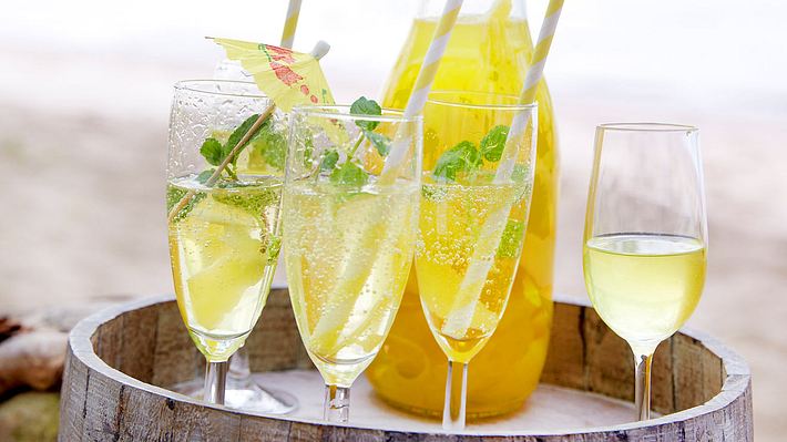 4 Gläser Limoncello Spritz mit Trinkhalm und Schirmchen auf einem Servierbrett  - Foto: LECKER @ Bauer Media Group
