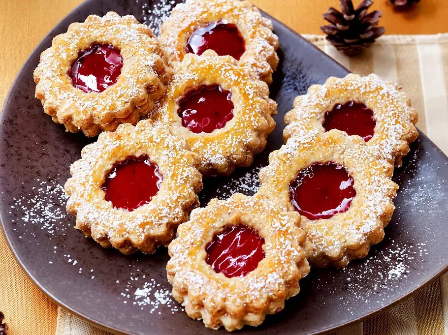 Linzer Plätzchen - Mürbeteigkekse mit einem Loch in der Mitte, in dem Marmelade ist, bestäubt mit Puderzucker