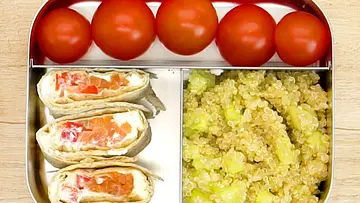 Drei Wrapstücke mit Frischkäse und Gemüse, dazu Kirschtomaten und Quinoa-Salat mit Gurke appetitlich in einer Edelstahl-Lunchbox angerichtet. - Foto: LECKER @ Bauer Media Group